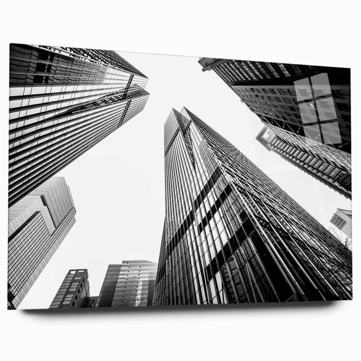 Large abstract wall art of skyscraper designs in gray and silver tones on acrylic glass.
