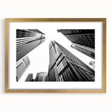 Textured abstract art print of skyscrapers in muted gray and gold tones on a framed canvas, suitable for bedroom decor.