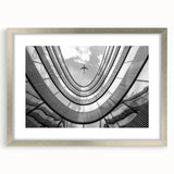 Abstract art print of skyscrapers in muted gray and silver tones, framed in silver.