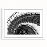 Abstract art print of a spiral staircase in monochrome, framed in white, suitable for bedroom or dining room decor.