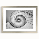 Textured abstract art print of a spiral staircase in muted gray tones, framed in silver, ideal for bedroom art.