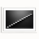 Abstract art print of a spiral staircase in black and white, framed in white, suitable for bedroom or dining room decor.