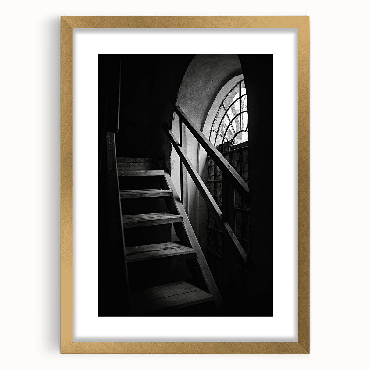 Abstract art print of a spiraling staircase in neutral shades, framed in gold.