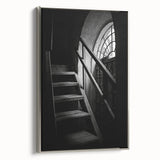 Framed canvas featuring a black and white spiral staircase in a vintage poster style.