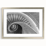 Textured abstract art print of a spiral staircase in muted gray tones, framed in silver, ideal for bedroom art.
