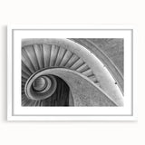 Abstract art print of a spiral staircase in black and white, framed with a white mat, suitable for dining or bedroom decor.