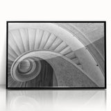 Large abstract wall art featuring a spiral staircase design in black and white, presented in a framed acrylic.