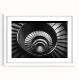 Abstract art print of a spiral staircase in monochrome, framed in white, ideal for modern dining room decor.