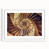 Abstract art print of a spiral staircase in monochrome, framed in white, suitable for bedroom or dining room decor.