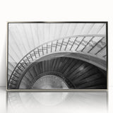 Mid-century modernist art of a spiral staircase in muted gray tones, framed in silver acrylic.