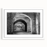 Abstract art print of geometric tunnel designs in black and white, framed with a white mat.