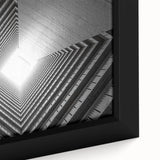 Close-up of a black, textured wall art piece featuring a colorful, abstract tunnel design on a framed canvas.