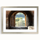 Abstract art print of geometric shapes in muted gray and silver, framed with a mat in a silver frame.