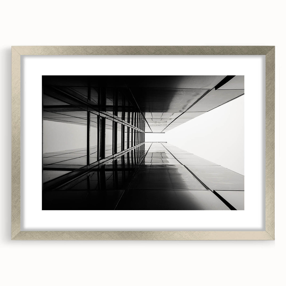 Abstract art print featuring geometric patterns in muted gray and silver, framed in silver.