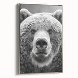 Framed wall art featuring a striking black bear design on canvas, showcased with a sleek silver frame, ideal for nature enthusiasts and modern decor.