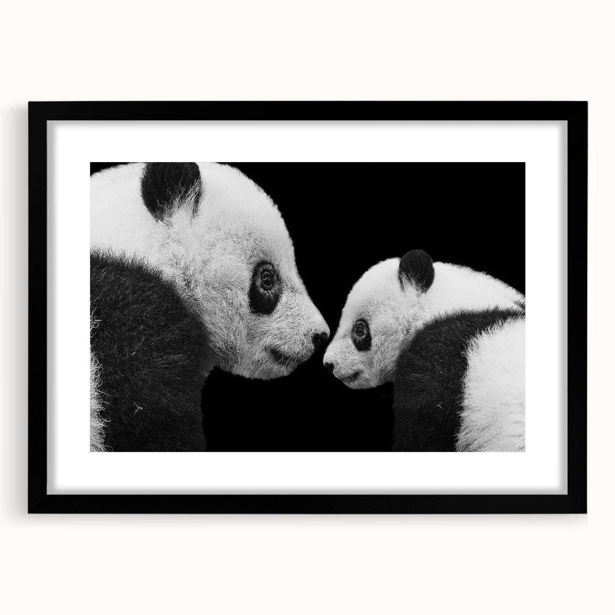 Framed black wall art featuring a whimsical panda bear design, presented with a white mat for a modern touch, ideal for children's rooms or playful decor.