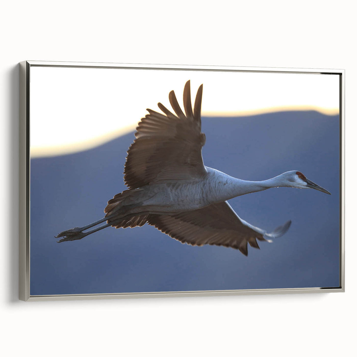 Framed wall art featuring a serene crane design in silver tones, elegantly displayed from a side view, perfect for enhancing modern home decor.