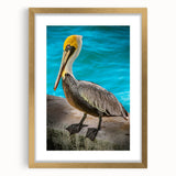 Elegant framed wall art featuring a pelican design in soft pastel colors, encased in a gold frame with a mat, perfect for coastal home decor.