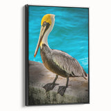 Framed wall art featuring a side view of a pelican design on textured canvas, highlighted by a sleek black frame, perfect for coastal decor enthusiasts.