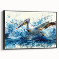 Framed canvas wall art showcasing a serene pelican design, featuring soft blue and earthy tones, set against a sleek black frame, perfect for coastal decor.