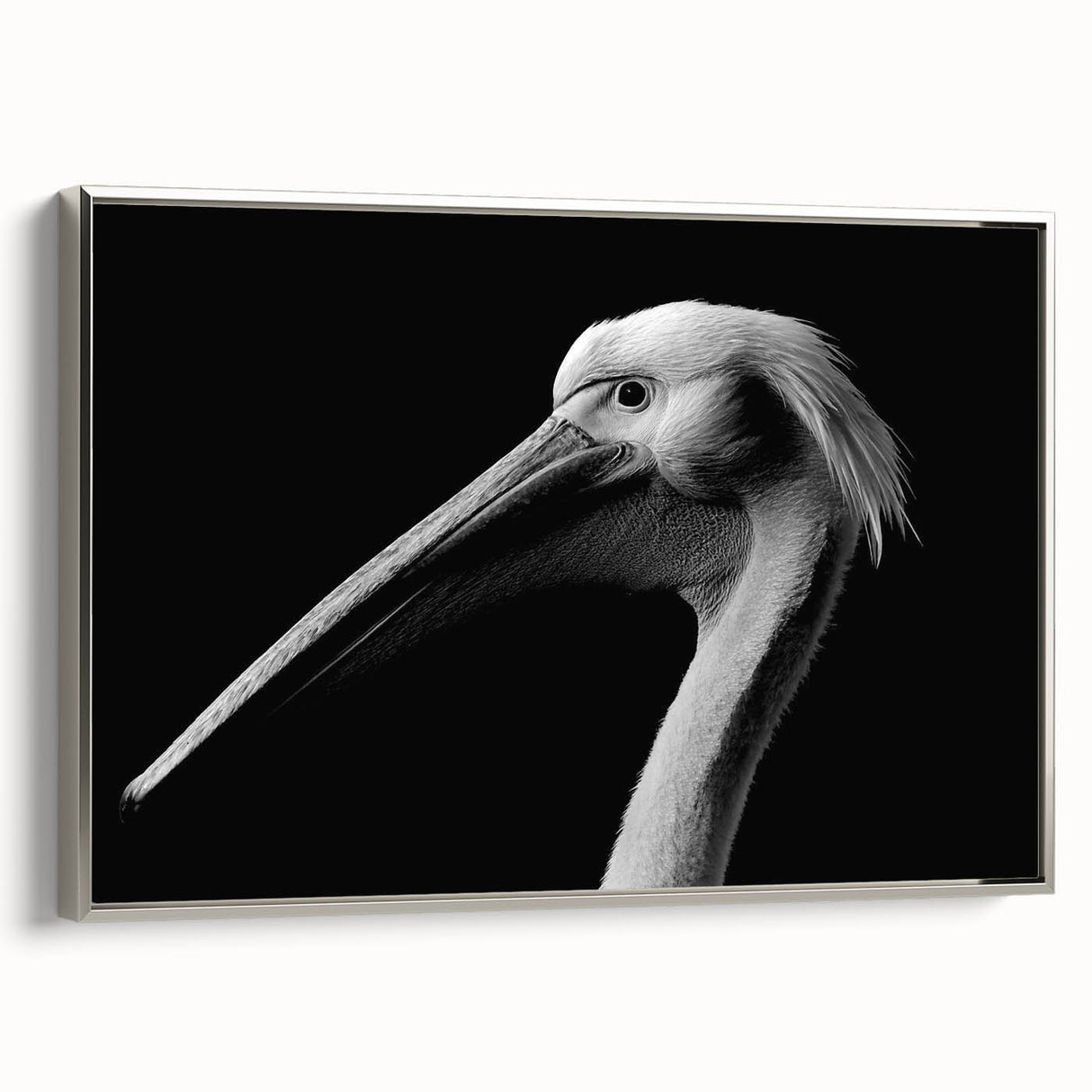 Framed wall art showcasing a side view of a silver pelican design on canvas, ideal for coastal home decor and bird enthusiasts, adding elegance to any room.