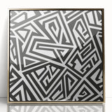 Framed black and white abstract wall art with a sleek gold border, showcasing dynamic shapes and contrasting patterns for modern decor.