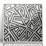 Framed abstract wall art with black and white geometric designs, showcasing modern aesthetics and a sleek white frame, perfect for contemporary decor.