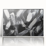 Framed black and white abstract wall art featuring dynamic geometric shapes and lines, displayed against a clean white background for modern decor.
