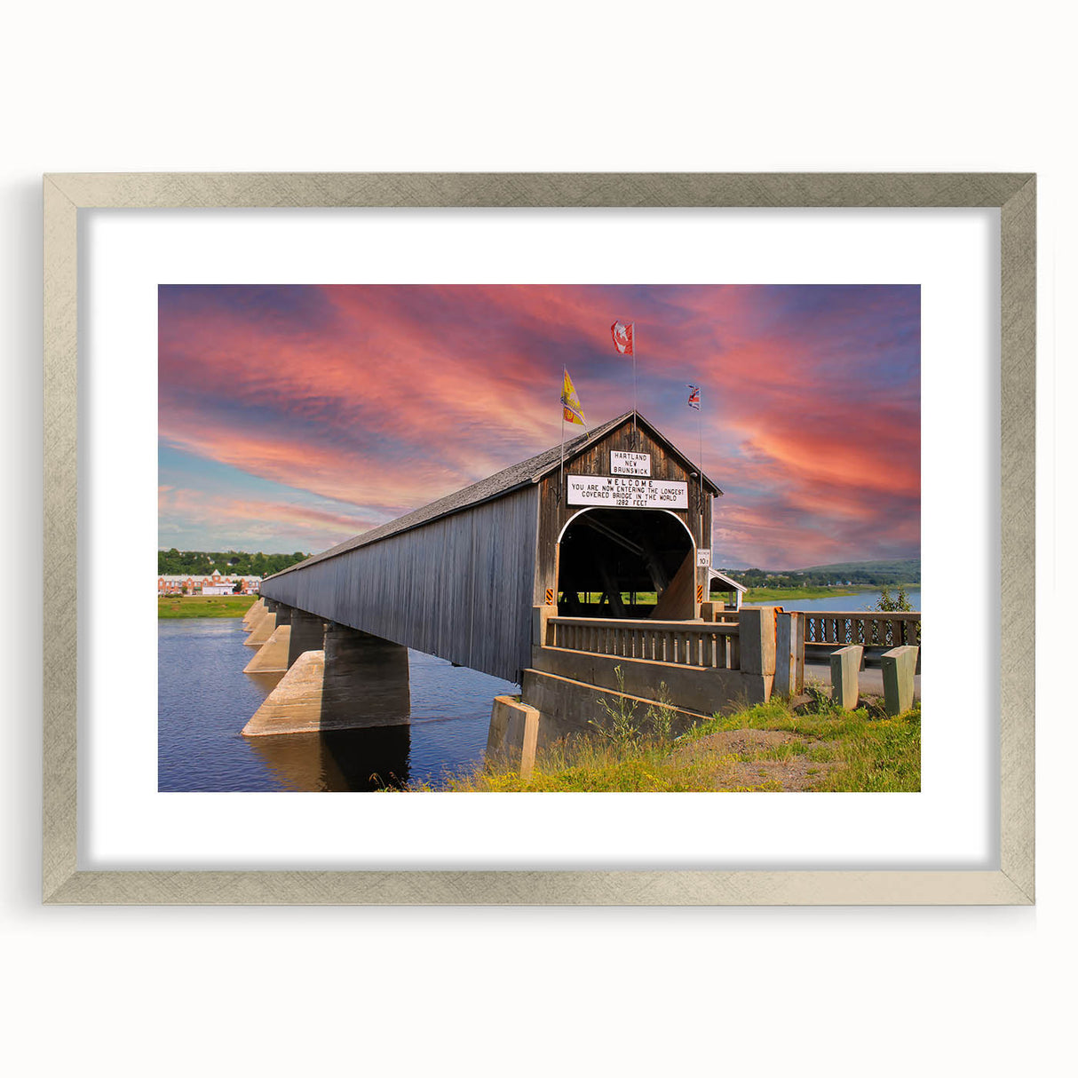 Textured art print of a covered bridge in muted earth tones on a framed silver mat, suitable for bedroom decor.