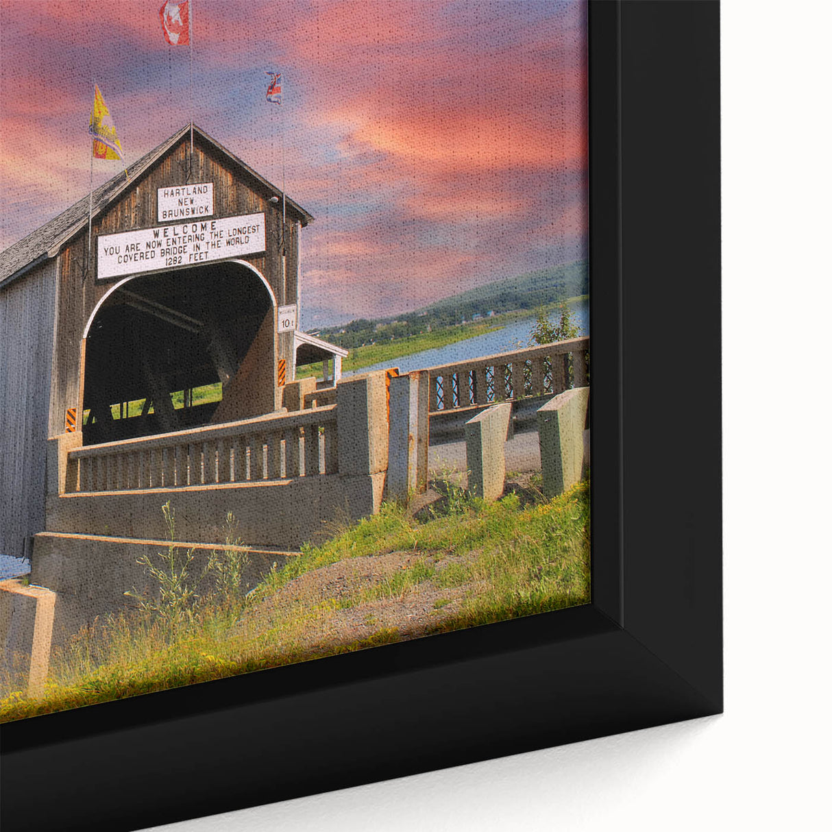 Close-up of a textured framed canvas depicting a black covered bridge with colorful accents, ideal for living room decor.