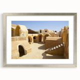 Abstract art print depicting a Moroccan landscape in muted earth tones on a framed silver mat.