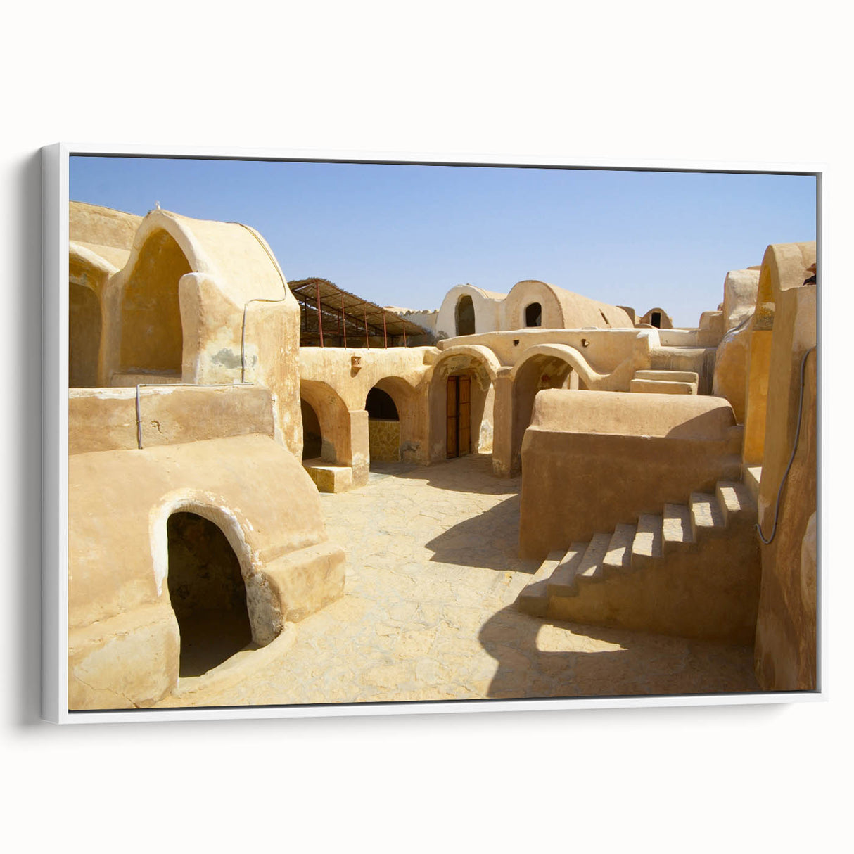 Framed canvas wall art featuring a vintage-style Moroccan landscape in muted earth tones, ideal for bedroom decor.