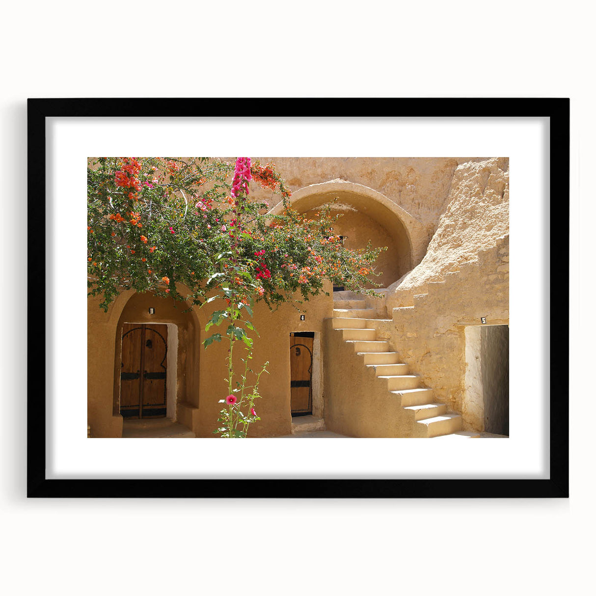 Abstract art print of colorful, textured scenery depicting Tunisia, framed in black, ideal for living room decor.