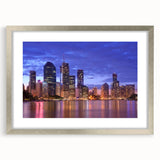 Abstract art print of Brisbane skyline in muted blue and gray tones, framed in silver.