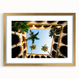 Abstract art print of a Caribbean scene in a gold frame, featuring vibrant blue and green tones, ideal for dining room decor.