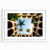 Textured abstract art print depicting a Caribbean scenery in muted blue and green tones, framed in white.