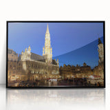 Large abstract wall art depicting a European scenery in muted earth tones, framed in black acrylic.