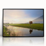 Large abstract wall art depicting a stylized European landscape in muted earth tones, framed in black acrylic.