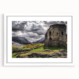 Abstract art print of a Welsh landscape in muted green and blue tones, framed with a white mat.