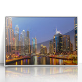 Acrylic print of Dubai skyline in muted gray and blue tones, framed in white, suitable for modern art wall decor.
