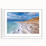 Abstract art print of the Dead Sea in muted blue and beige tones, framed with a white mat, suitable for dining room decor.