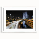 Abstract art print of Tel Aviv skyline in muted gray and blue tones on a framed white mat, ideal for dining room decor.