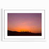 Abstract art print of a Middle Eastern desert scenery in muted beige and blue, framed with a white mat.
