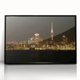 Large abstract wall art of Auckland's skyline in muted gray and blue tones on a black framed acrylic.