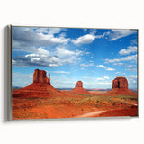 Framed canvas depicting Monument Valley in vibrant red and orange tones, ideal for a living room or study.