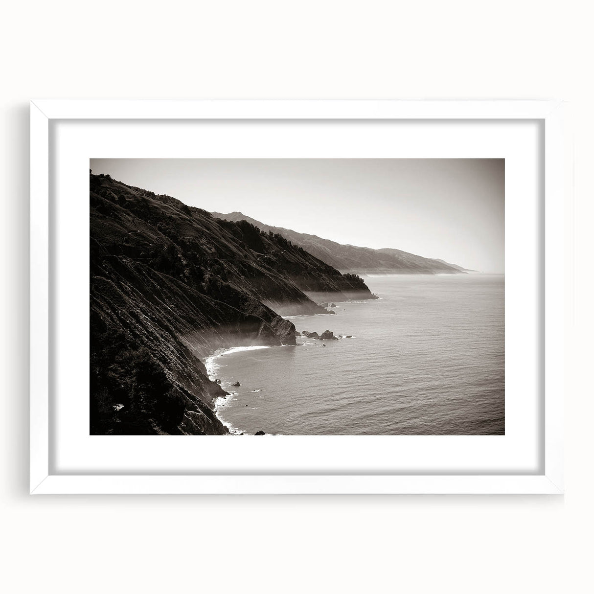 Abstract art print of California's Big Sur in muted blue and green tones, framed with a white mat.