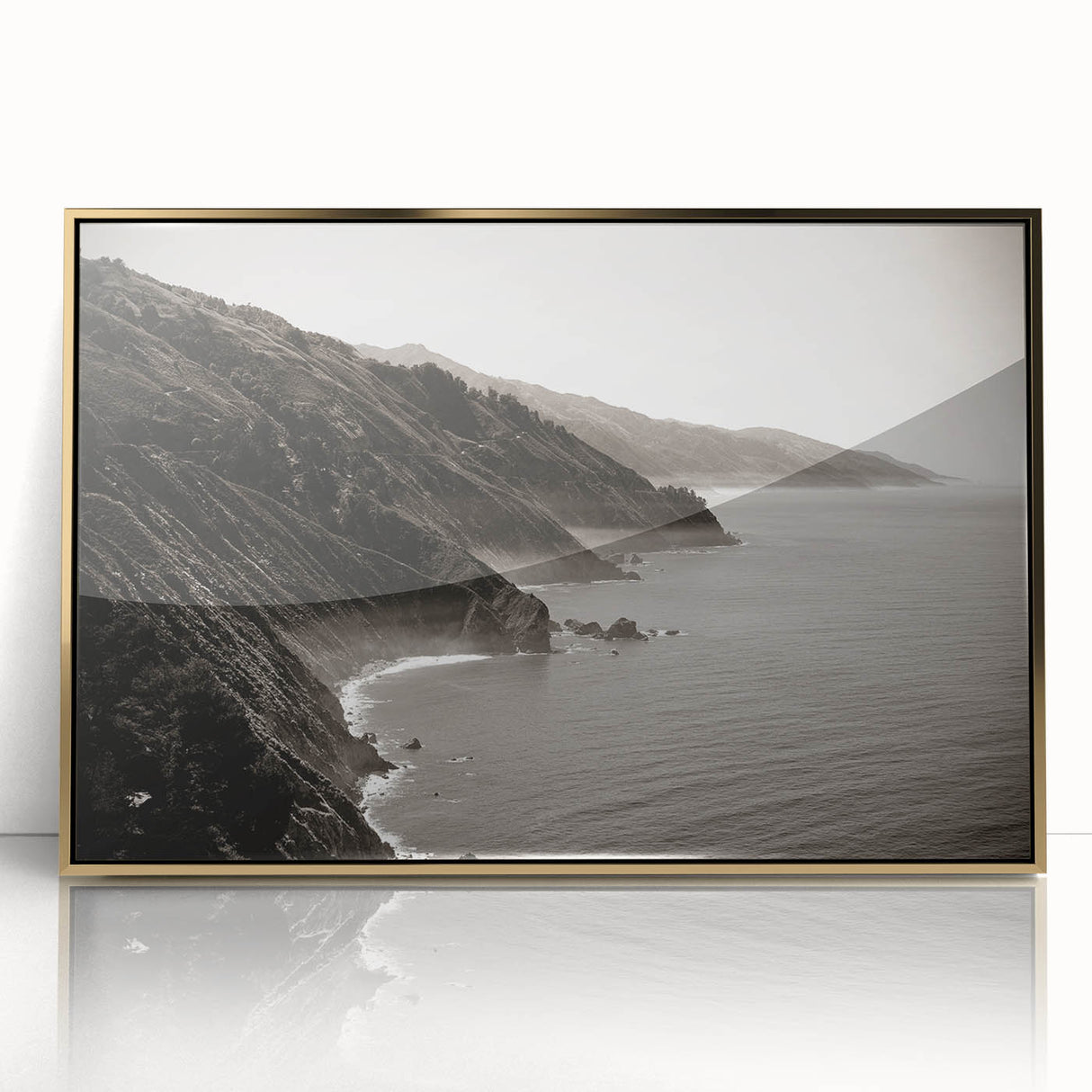 Large acrylic print of Big Sur coastline in gold frame, featuring mid-century modernist style.
