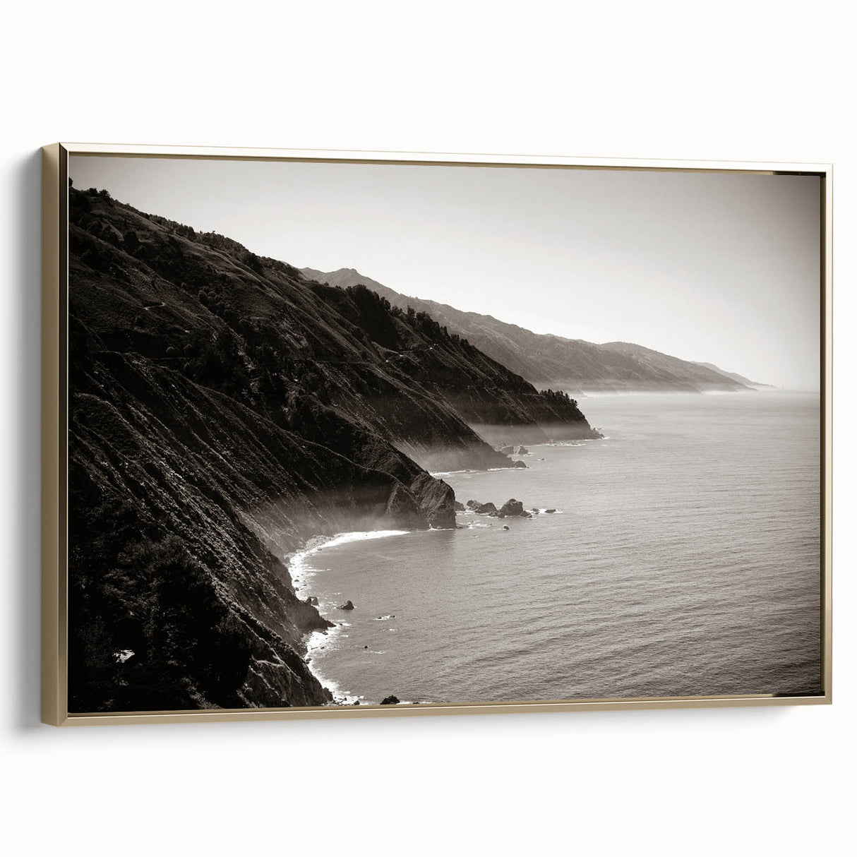 Framed canvas wall art featuring a vintage-style landscape of Big Sur, California in muted gold and black tones.