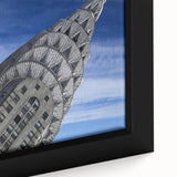 Close-up of black wall art featuring a textured depiction of the Chrysler Building in colorful hues on a framed canvas.