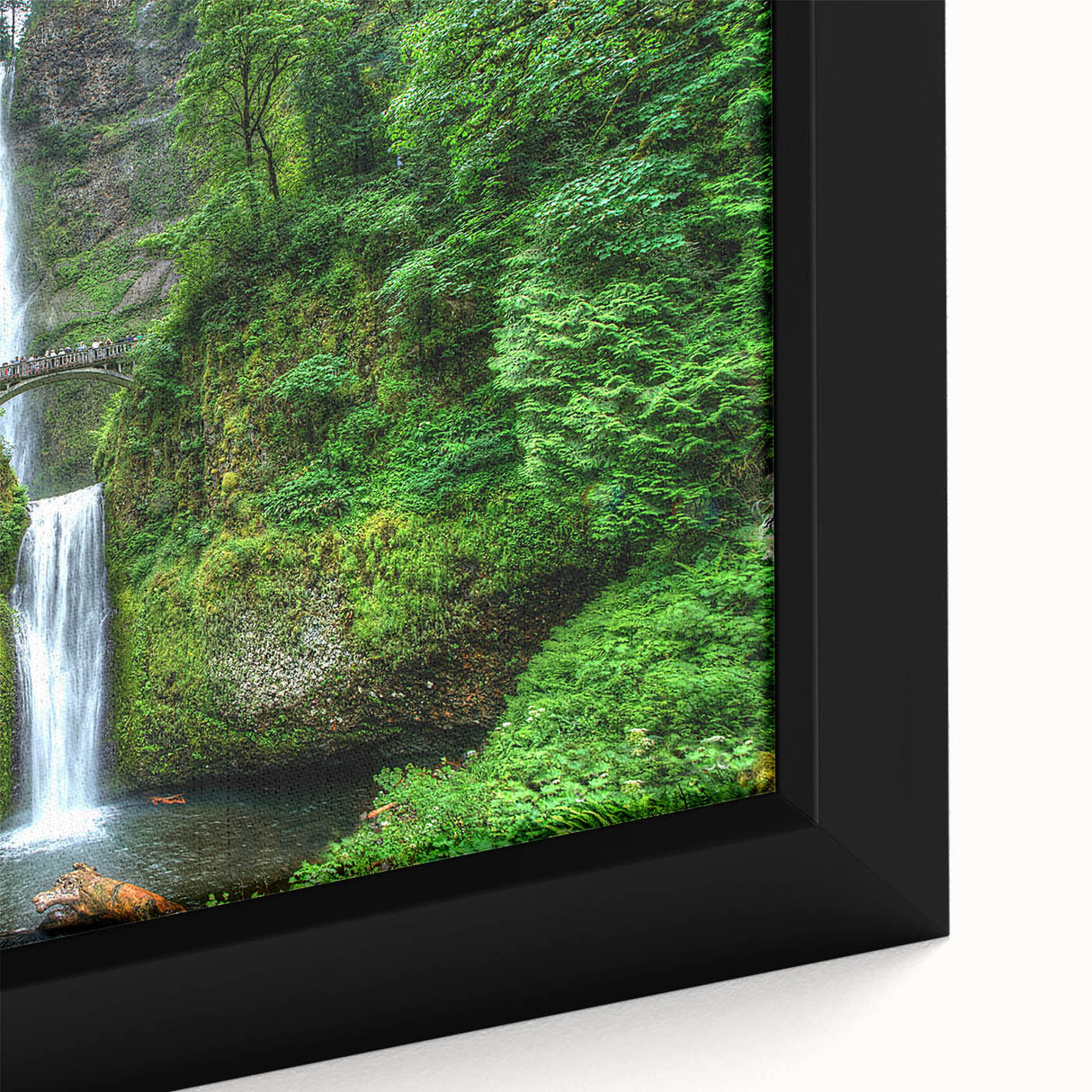 Close-up of a black framed canvas depicting Multnomah Falls in Oregon, featuring vibrant green and blue tones.